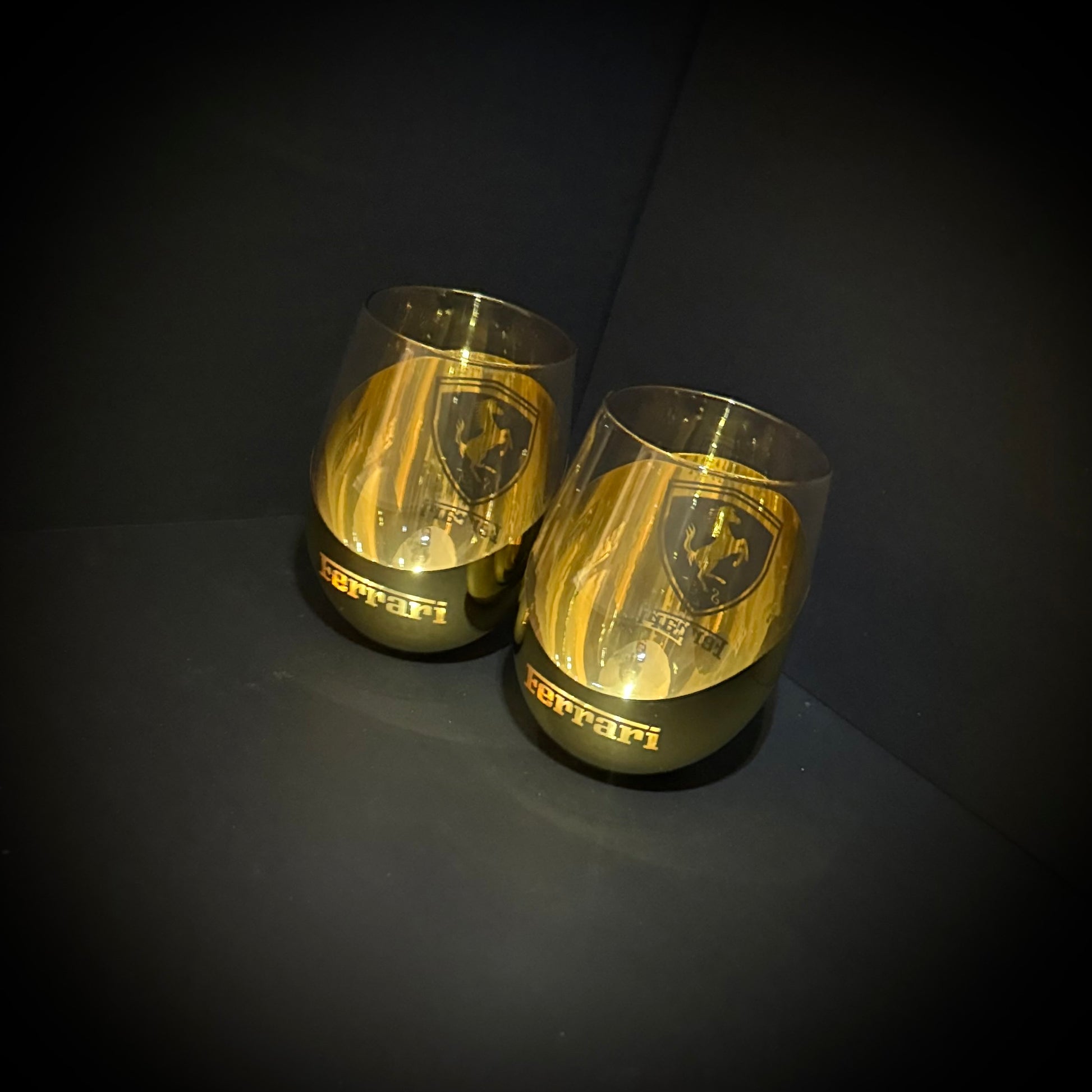 Two gold Ferrari-themed glasses