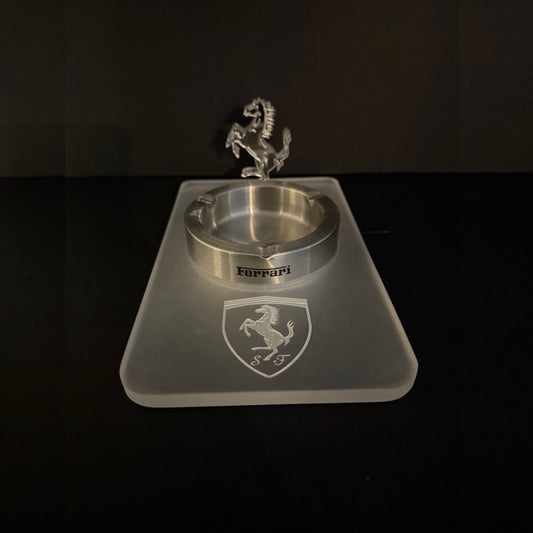 A clear acrylic ashtray with an engraved Ferrari shield and a 3D prancing horse figure mounted on a frosted acrylic base.