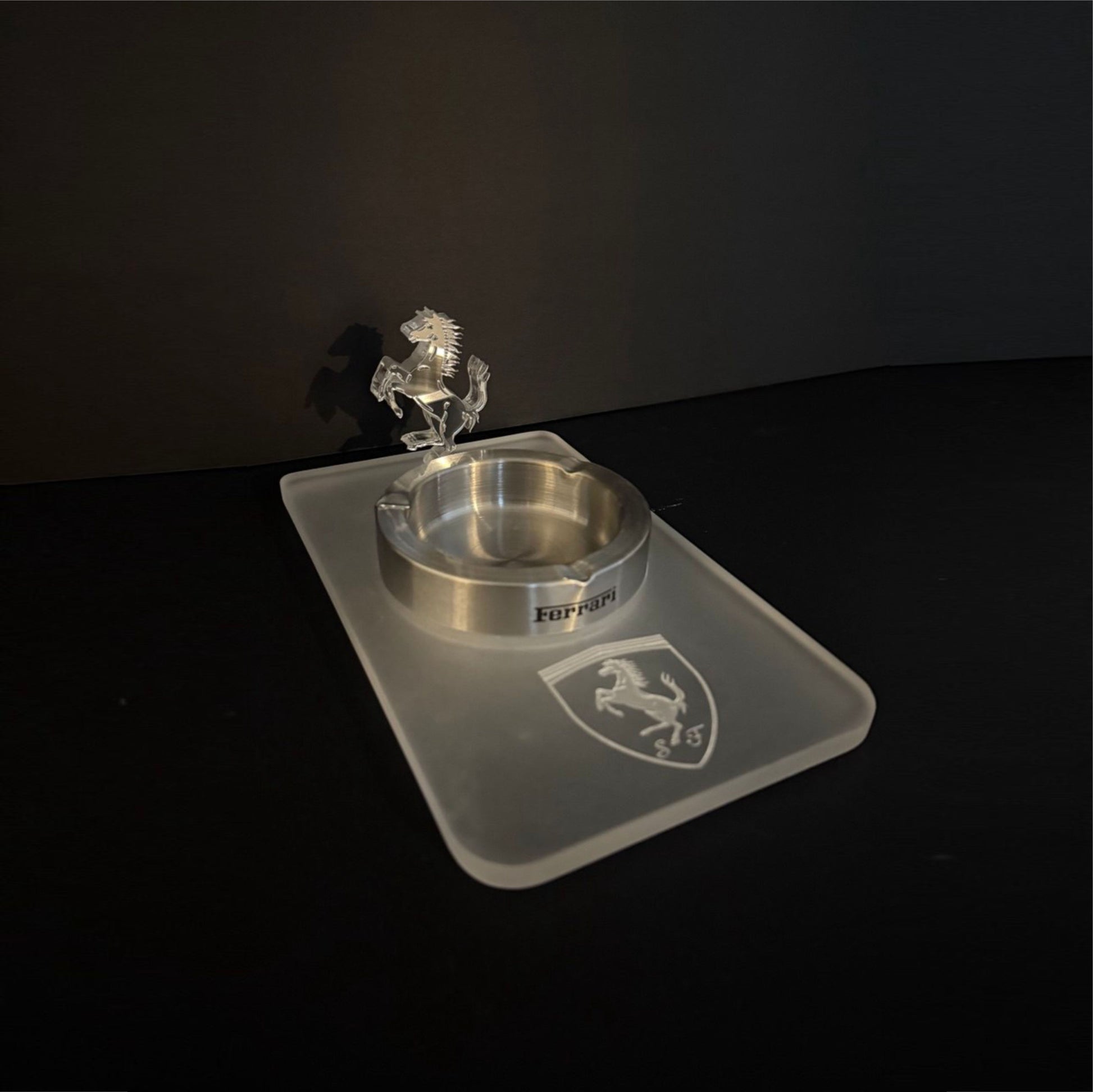 Side-angle view of a handcrafted acrylic Ferrari ashtray featuring a frosted base and a clear 3D prancing horse figure.