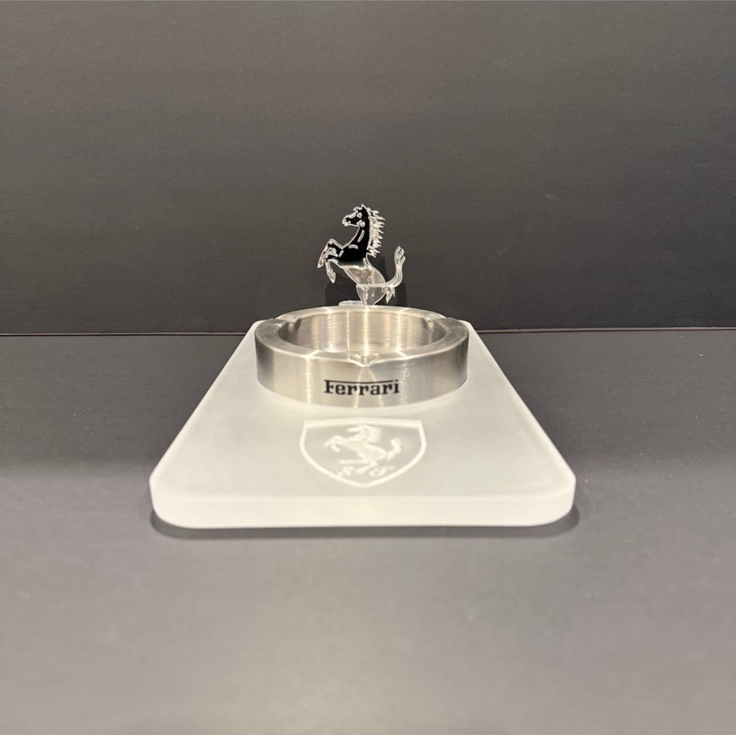 Front-facing view of a fully acrylic luxury ashtray with an engraved Ferrari shield and upright prancing horse sculpture.