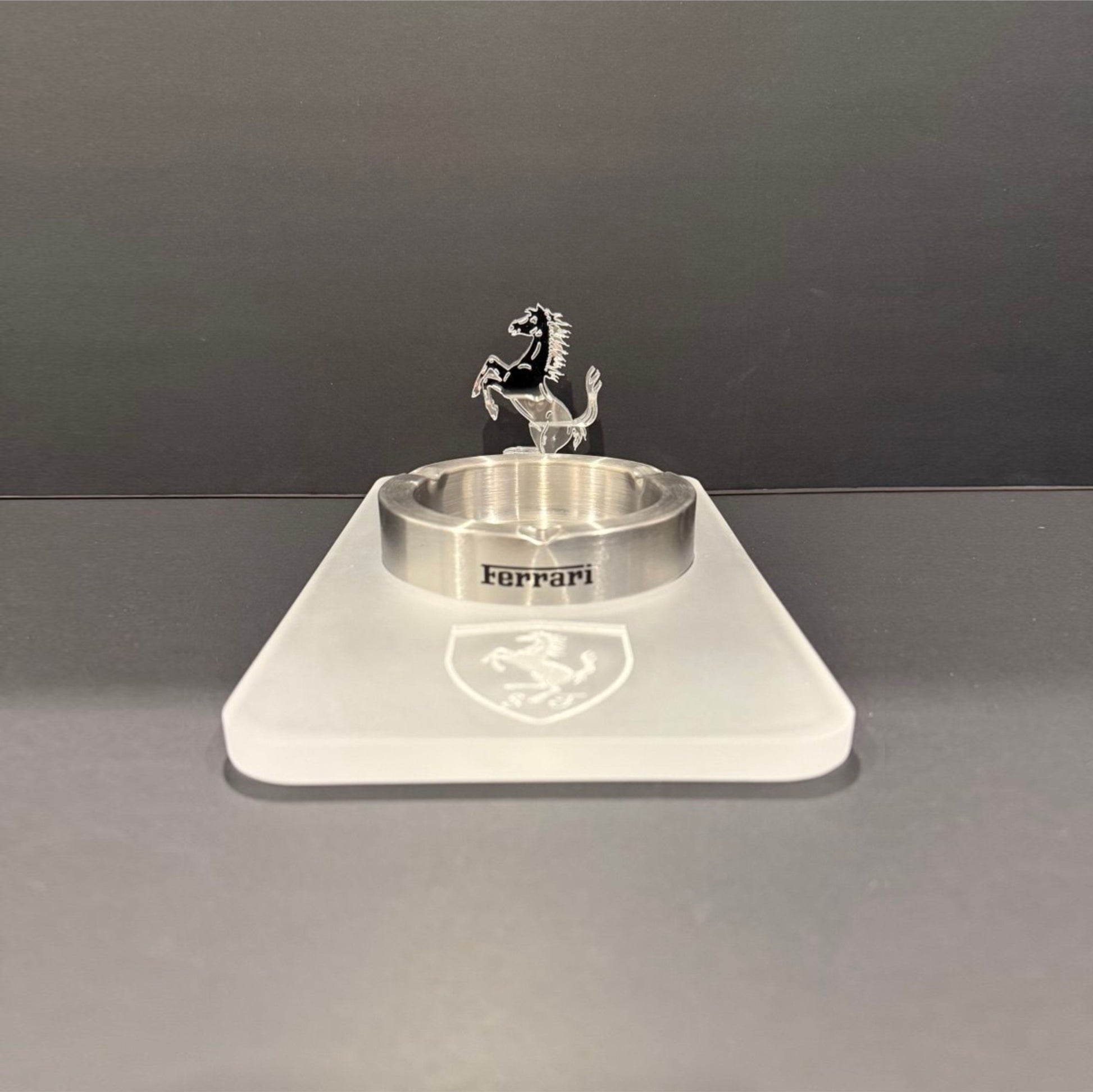 Front-facing view of a fully acrylic luxury ashtray with an engraved Ferrari shield and upright prancing horse sculpture.