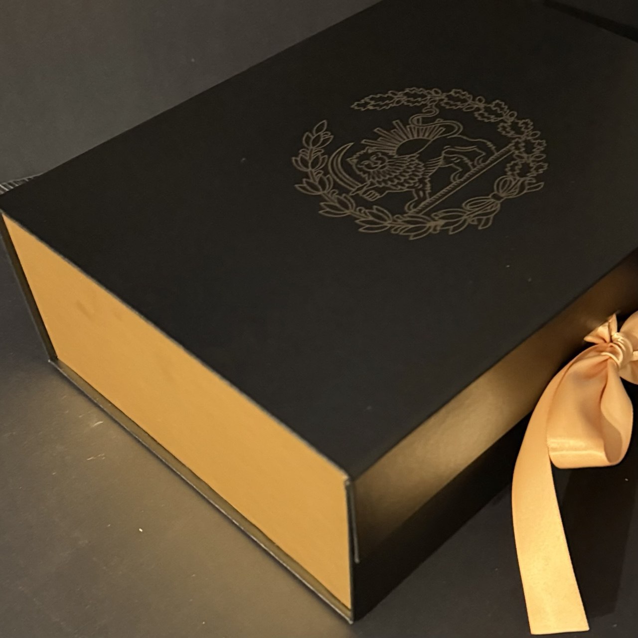 Luxury black gift box with gold interior and Persian Lion and Sun emblem, premium packaging for wine glass set