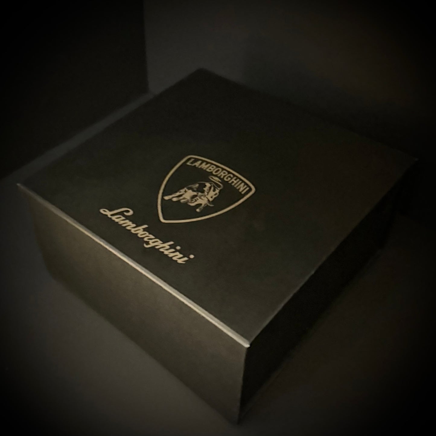 Black Lamborghini branded box on a dark background