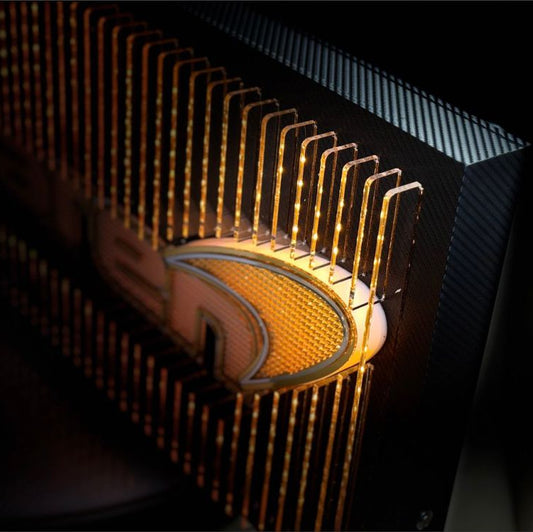 McLaren-inspired illuminated acrylic wall art featuring layered fins, carbon-fiber backing, and warm orange LED lighting, with detailed micro-logo textures across the design.