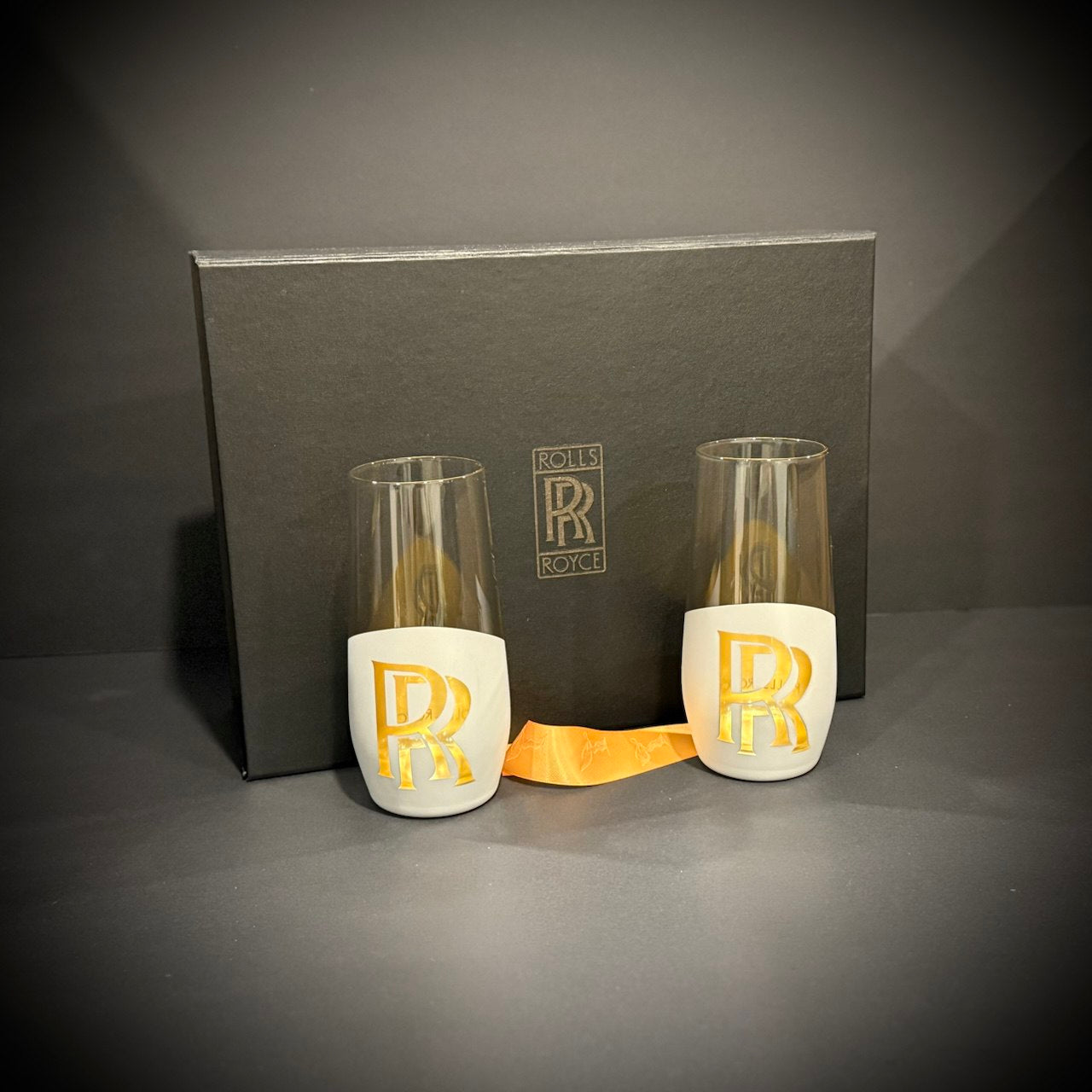 Silver and gold engraved spirit-inspired glasses presented with premium black and gold gift box for luxury barware display