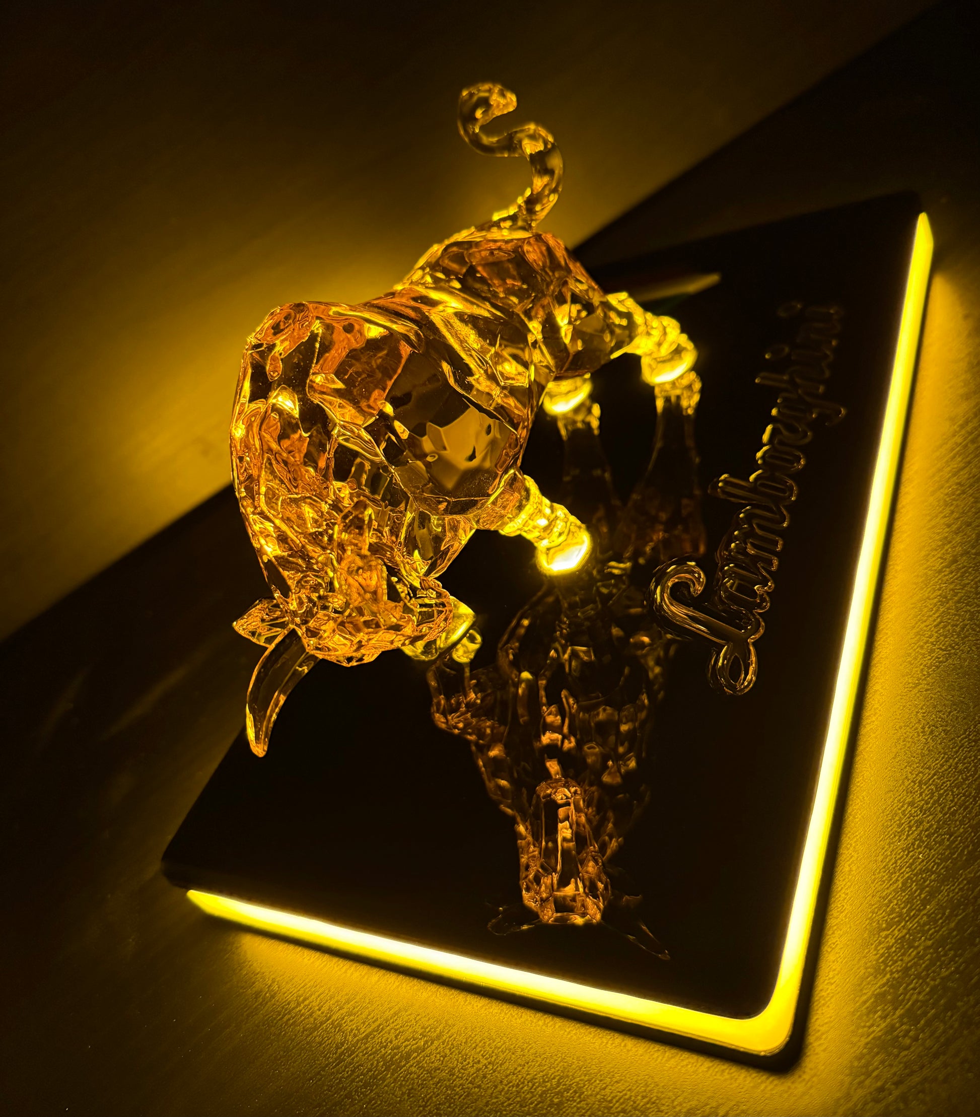 Handcrafted illuminated bull sculpture on a black platform with visible Gold LED, diagonal top view.