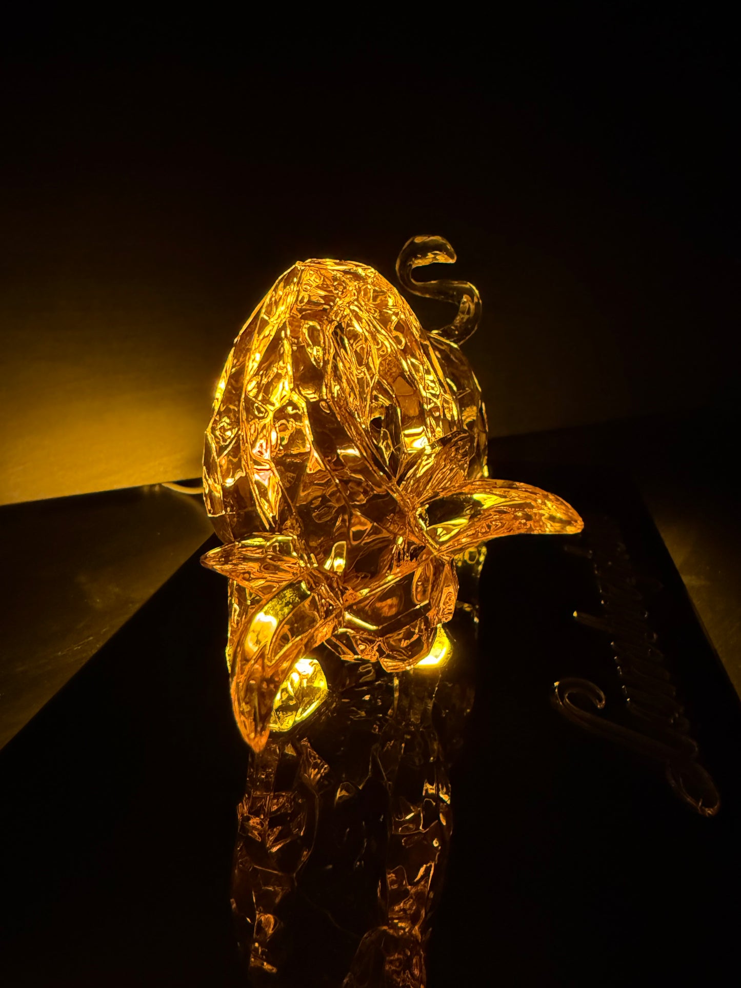 Golden bull statue photographed from the front with dramatic shadow and warm accent lighting.