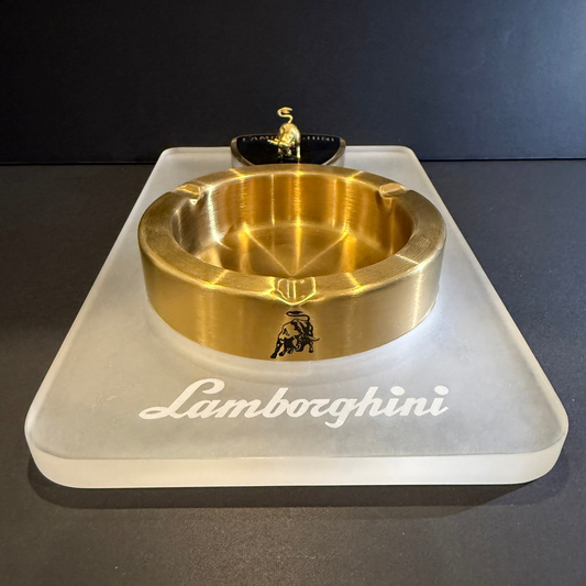Gold Lamborghini ashtray on a white base with 'Lamborghini' branding.