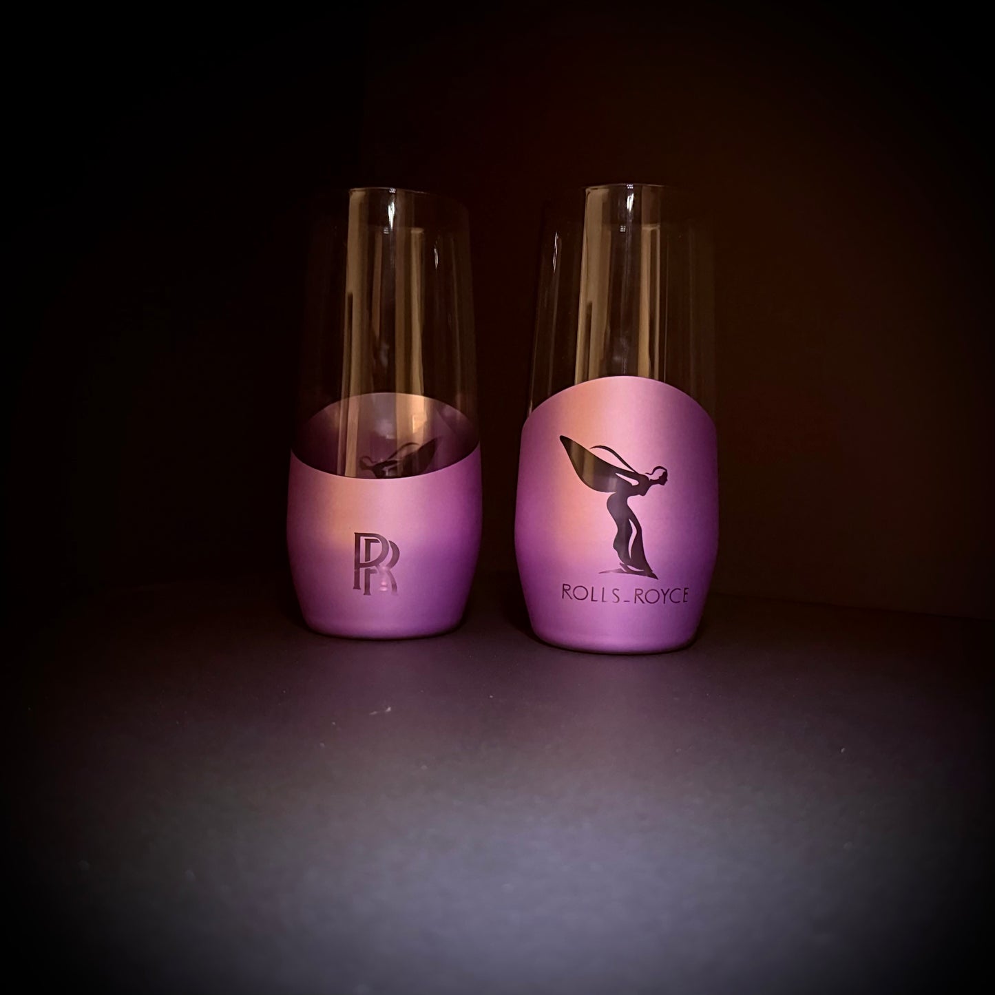 A set of luxury purple stemless glasses with Spirit and RR-inspired engravings on a black background.